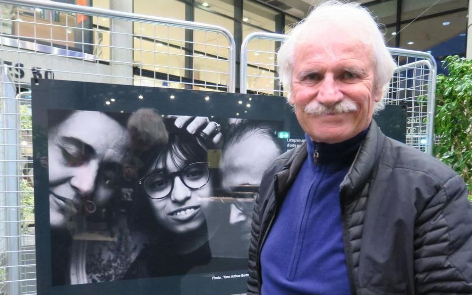 Yann Arthus-Bertrand devant l’une de ses photographies, à l’exposition « Je suis autiste et alors ? »